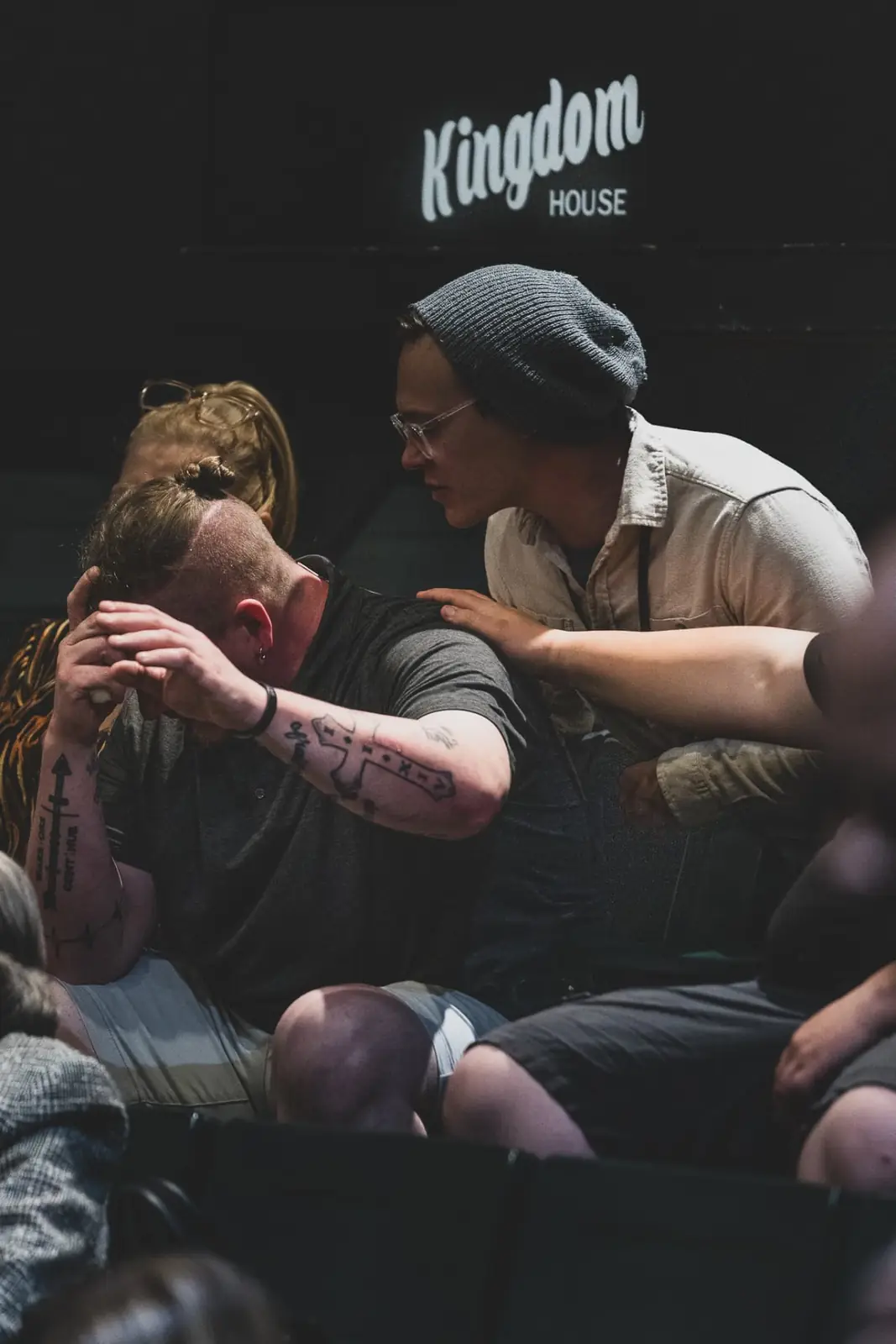 Two men praying together after a Sunday service at Kingdom House