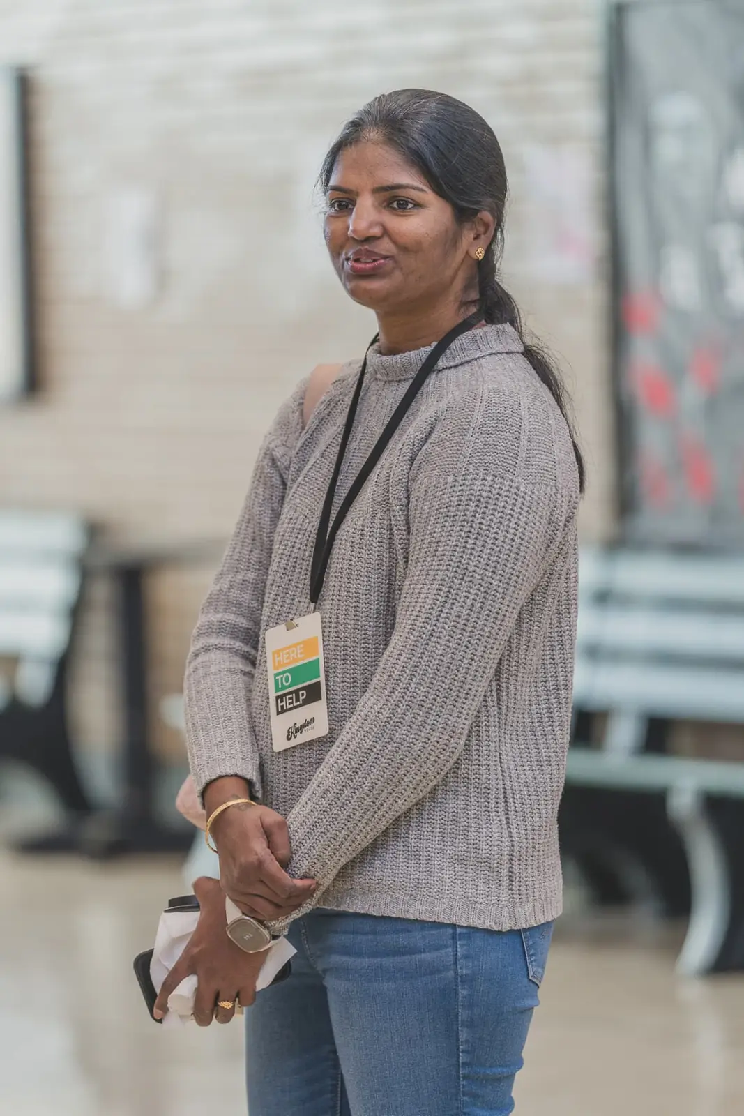 A Kingdom House volunteer wearing a Here To Help badge in the lobby